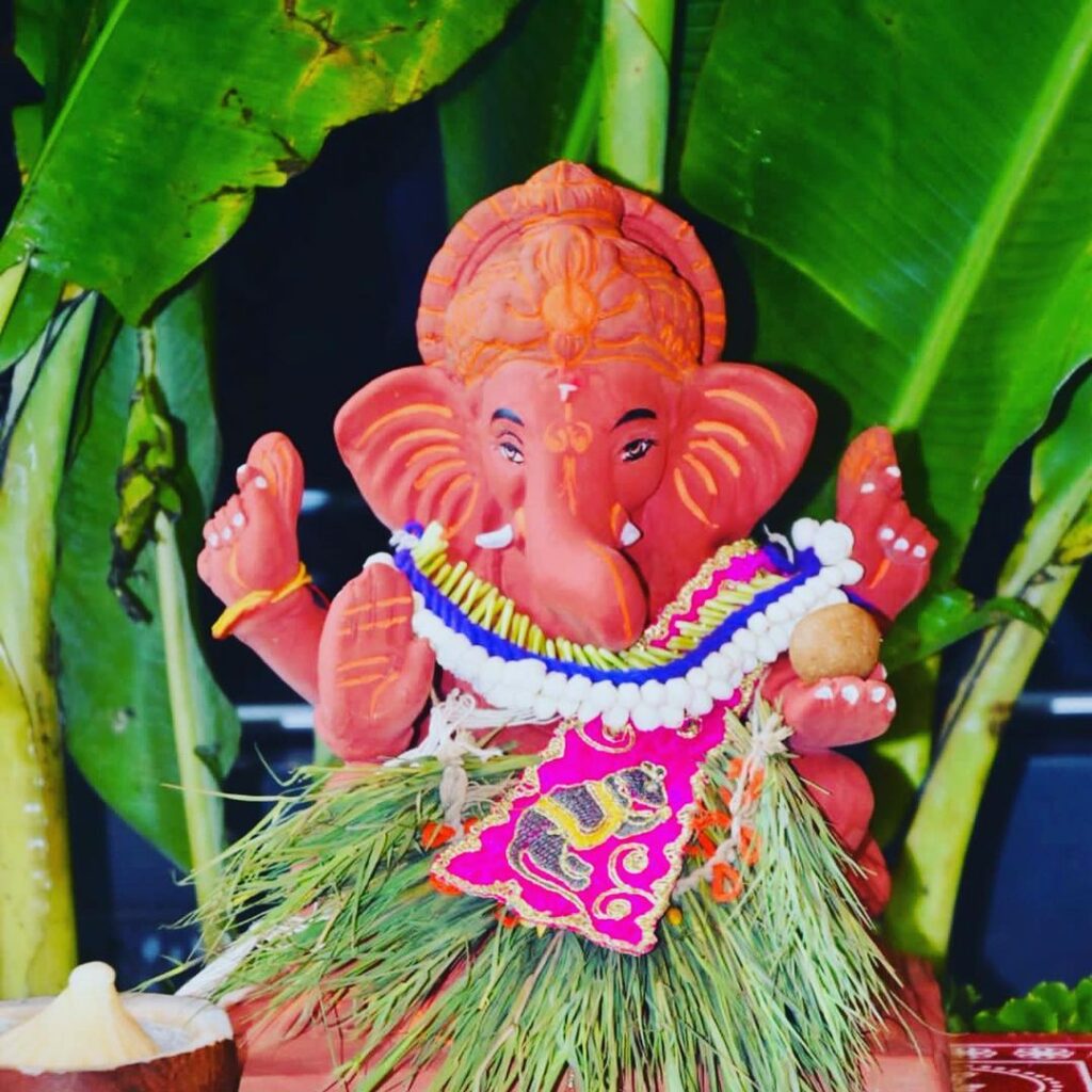 "Decorated idol of Lord Ganesha adorned with flowers and traditional offerings during Ganesh Chaturthi Puja, signifying the start of the festival celebrations."