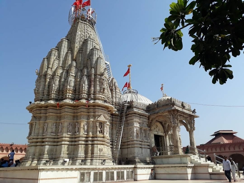 "Colorful flags waving at Ma Umiya temple during Dhaja Mahotsav in Unjha, Gujarat, with devotees participating in the joyous celebration"