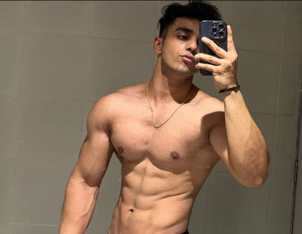 "Aarush Bhola - Indian social media influencer, fitness expert, and clothing brand founder posing with a confident smile."