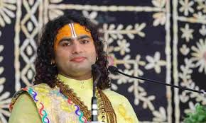 "Shri Aniruddhacharya Ji Maharaj delivering a spiritual discourse in front of an audience, symbolizing his role as a spiritual guide and social servant."